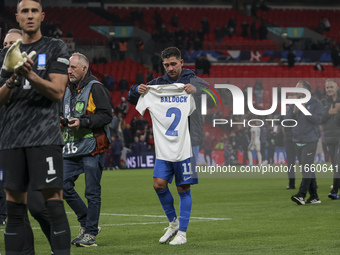 Tasos Bakasetas holds an official jersey with the name BALDOCK while he appears emotional. The Greek team heads to the Greek fans to celebra...