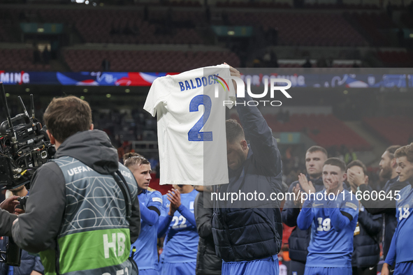 Tasos Bakasetas holds an official jersey with the name BALDOCK while he appears emotional. The Greek team heads to the Greek fans to celebra...