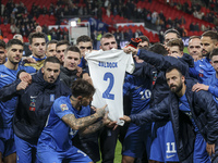 The Greek team stands in front of the side with the Greek fans, celebrating and thanking them. They dedicate their win to their late teammat...