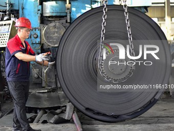 Workers work at a stainless steel material processing enterprise in Qingzhou, China, on October 13, 2024. (