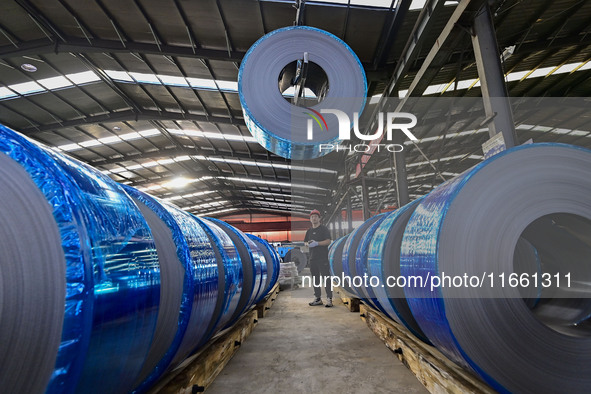 Workers work at a stainless steel material processing enterprise in Qingzhou, China, on October 13, 2024. 