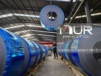 Workers work at a stainless steel material processing enterprise in Qingzhou, China, on October 13, 2024. (