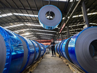 Workers work at a stainless steel material processing enterprise in Qingzhou, China, on October 13, 2024. (