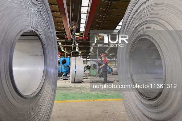 Workers work at a stainless steel material processing enterprise in Qingzhou, China, on October 13, 2024. 