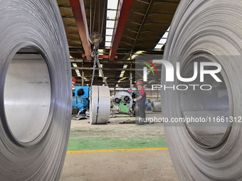 Workers work at a stainless steel material processing enterprise in Qingzhou, China, on October 13, 2024. (