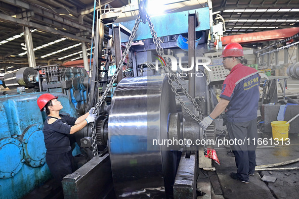 Workers work at a stainless steel material processing enterprise in Qingzhou, China, on October 13, 2024. 