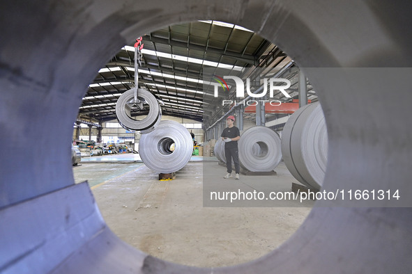 Workers work at a stainless steel material processing enterprise in Qingzhou, China, on October 13, 2024. 