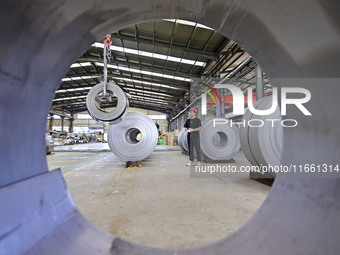 Workers work at a stainless steel material processing enterprise in Qingzhou, China, on October 13, 2024. (