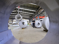 Workers work at a stainless steel material processing enterprise in Qingzhou, China, on October 13, 2024. (