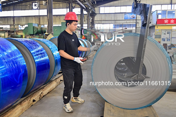 Workers work at a stainless steel material processing enterprise in Qingzhou, China, on October 13, 2024. 