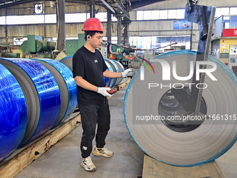 Workers work at a stainless steel material processing enterprise in Qingzhou, China, on October 13, 2024. (