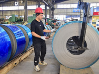 Workers work at a stainless steel material processing enterprise in Qingzhou, China, on October 13, 2024. (