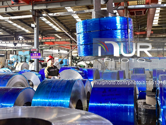 Workers work at a stainless steel material processing enterprise in Qingzhou, China, on October 13, 2024. (