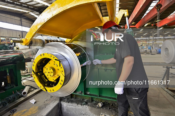 Workers work at a stainless steel material processing enterprise in Qingzhou, China, on October 13, 2024. 