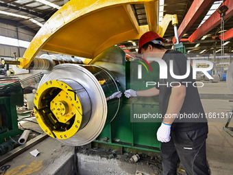 Workers work at a stainless steel material processing enterprise in Qingzhou, China, on October 13, 2024. (