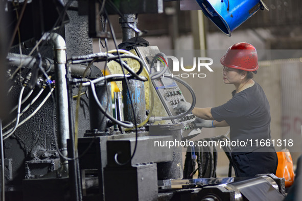 Workers work at a stainless steel material processing enterprise in Qingzhou, China, on October 13, 2024. 