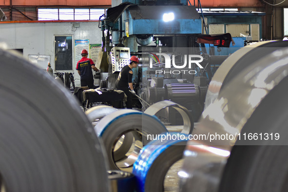 Workers work at a stainless steel material processing enterprise in Qingzhou, China, on October 13, 2024. 