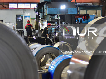 Workers work at a stainless steel material processing enterprise in Qingzhou, China, on October 13, 2024. (