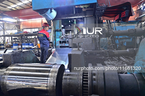 Workers work at a stainless steel material processing enterprise in Qingzhou, China, on October 13, 2024. 