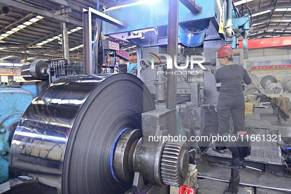 Workers work at a stainless steel material processing enterprise in Qingzhou, China, on October 13, 2024. 