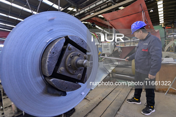 Workers work at a stainless steel material processing enterprise in Qingzhou, China, on October 13, 2024. 