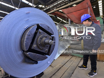 Workers work at a stainless steel material processing enterprise in Qingzhou, China, on October 13, 2024. (