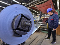 Workers work at a stainless steel material processing enterprise in Qingzhou, China, on October 13, 2024. (