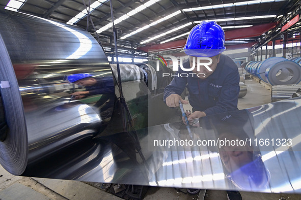 Workers work at a stainless steel material processing enterprise in Qingzhou, China, on October 13, 2024. 