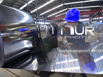 Workers work at a stainless steel material processing enterprise in Qingzhou, China, on October 13, 2024. (