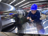 Workers work at a stainless steel material processing enterprise in Qingzhou, China, on October 13, 2024. (