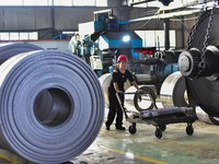 Workers work at a stainless steel material processing enterprise in Qingzhou, China, on October 13, 2024. (