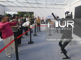 Citizens watch a universal pedestrian robot of Unitree Technology perform a dance performance at the 2024 Hangzhou (International) Future Li...