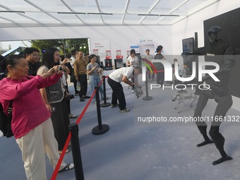 Citizens watch a universal pedestrian robot of Unitree Technology perform a dance performance at the 2024 Hangzhou (International) Future Li...