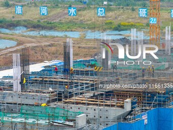 Workers brave the rain as they work at the construction site of the Erhe Junction project of the second phase of the Huaihe River Waterway i...