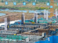 Workers brave the rain as they work at the construction site of the Erhe Junction project of the second phase of the Huaihe River Waterway i...