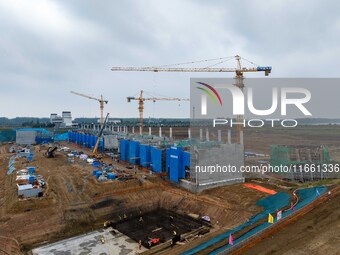 Workers brave the rain as they work at the construction site of the Erhe Junction project of the second phase of the Huaihe River Waterway i...