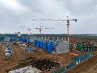 Workers brave the rain as they work at the construction site of the Erhe Junction project of the second phase of the Huaihe River Waterway i...