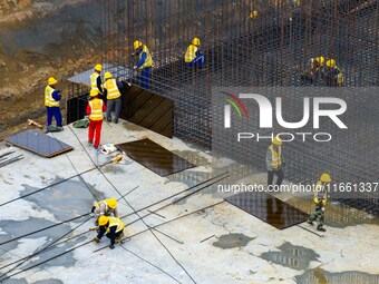 Workers brave the rain as they work at the construction site of the Erhe Junction project of the second phase of the Huaihe River Waterway i...