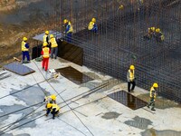 Workers brave the rain as they work at the construction site of the Erhe Junction project of the second phase of the Huaihe River Waterway i...