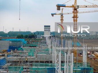 Workers brave the rain as they work at the construction site of the Erhe Junction project of the second phase of the Huaihe River Waterway i...