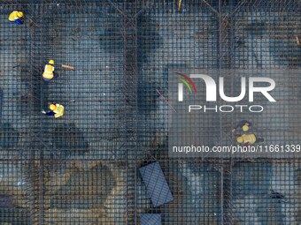 Workers brave the rain as they work at the construction site of the Erhe Junction project of the second phase of the Huaihe River Waterway i...