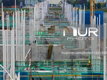 Workers brave the rain as they work at the construction site of the Erhe Junction project of the second phase of the Huaihe River Waterway i...