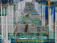 Workers brave the rain as they work at the construction site of the Erhe Junction project of the second phase of the Huaihe River Waterway i...