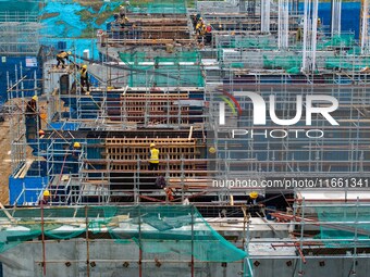 Workers brave the rain as they work at the construction site of the Erhe Junction project of the second phase of the Huaihe River Waterway i...