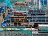 Workers brave the rain as they work at the construction site of the Erhe Junction project of the second phase of the Huaihe River Waterway i...