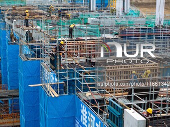 Workers brave the rain as they work at the construction site of the Erhe Junction project of the second phase of the Huaihe River Waterway i...