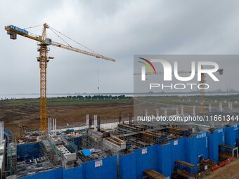 Workers brave the rain as they work at the construction site of the Erhe Junction project of the second phase of the Huaihe River Waterway i...