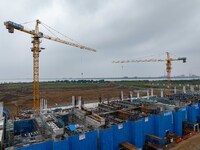 Workers brave the rain as they work at the construction site of the Erhe Junction project of the second phase of the Huaihe River Waterway i...