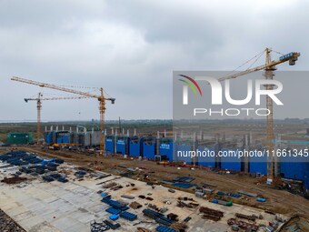 Workers brave the rain as they work at the construction site of the Erhe Junction project of the second phase of the Huaihe River Waterway i...