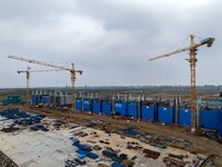 Workers brave the rain as they work at the construction site of the Erhe Junction project of the second phase of the Huaihe River Waterway i...